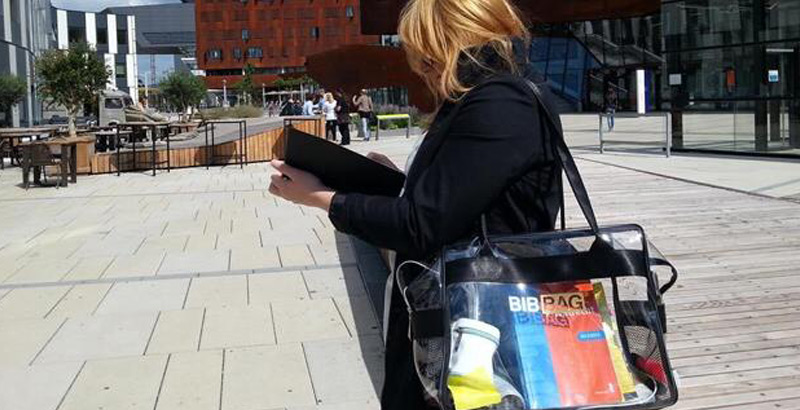Frau liest ein Buch und trägt eine Bibbag-Tasche